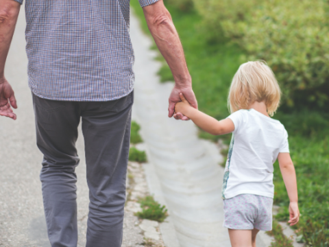 Elderly person and young child walking together